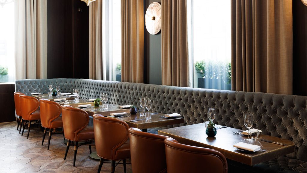 Wild Honey restaurant dining room with orange chairs and elegant table setting